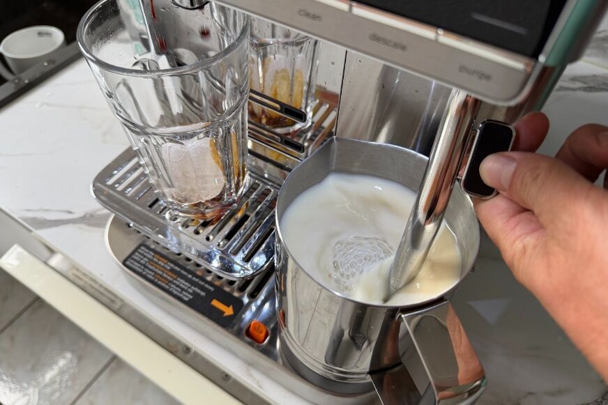 Ninja Auto Barista Pro erzeugt feinporigen Milchschaum für einen Cappuccino in einer weißen Tasse